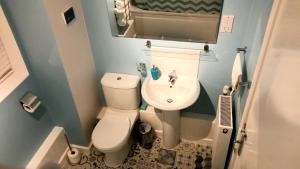 a small bathroom with a toilet and a sink at New Contemporary Flat minutes from Airport & NEC in Marston Green