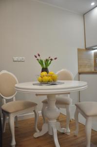 Biały stół z miską cytryn w obiekcie Golden Apartments - City Centrum w mieście Białystok