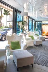 a room with white furniture and green pillows at Hotel Okinawa in Rimini