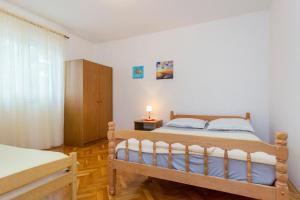 a bedroom with a bed and a dresser in it at Apartments Ivan in Vodice