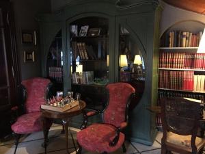 a room with two chairs and a table and books at Hotel City Bell in La Plata