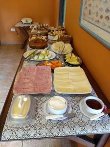 una mesa con queso y otros alimentos. en Pousada Tony Montana, en Praia de Araçatiba