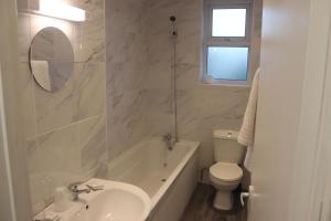 Baño blanco con lavabo y aseo en Corona Hotel Rotherham Sheffield Meadowhall en Rotherham