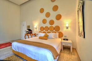 a bedroom with a large white bed with a large wall at Hotel Andante in Puebla