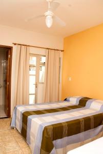 a bedroom with two beds and a ceiling fan at Orquídea Hotel in Viçosa