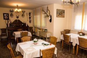 a restaurant with two tables and chairs with white table cloth at Finca Lebrel in Pedrola