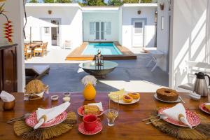 a table with plates of food on it with a pool at Pousada Casa de Paraty in Paraty