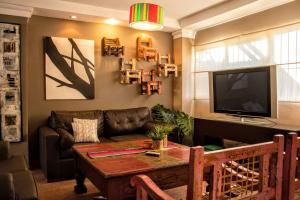 sala de estar con mesa, sofá y TV en Casa Los Sauces en Yerba Buena