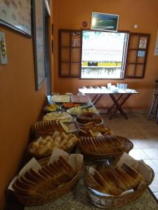 une table remplie de paniers de pain et de sandwichs dans l'établissement Pousada Tony Montana, à Praia de Araçatiba