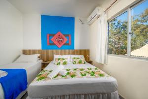 two beds in a room with a window at Mar e Mar Florianópolis in Florianópolis