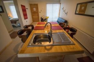 a kitchen with a sink in the middle of a table at Angelica's Rental House in Puerto Natales +27 photos