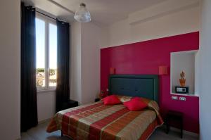 a bedroom with a bed with a red wall at MF Hotel in Rome