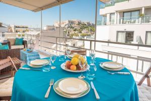 una mesa con un paño de mesa azul y un plato de fruta en Syntagma Spa with Acropolis View, en Atenas