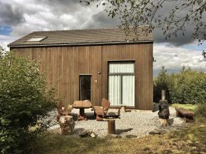 a building with a table and chairs in front of it at Cabin in the woods in Houffalize