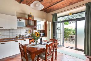 eine Küche mit einem Holztisch mit Stühlen und einem großen Fenster in der Unterkunft Casa Vacanze Bellavista in San Casciano in Val di Pesa