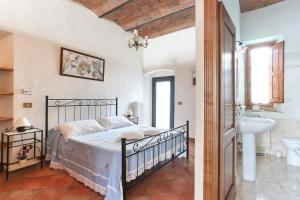 ein Schlafzimmer mit einem Bett und einem Waschbecken sowie ein Badezimmer in der Unterkunft Casa Vacanze Bellavista in San Casciano in Val di Pesa