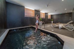 a woman is standing in a swimming pool at Bellevue Superior City Hotel in Šibenik