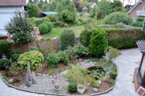 a garden with a small garden with plants and trees at Hana Aparthotel in Hamburg