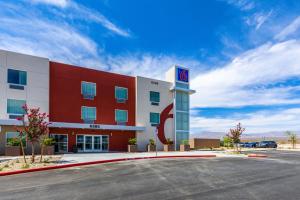 a hotel with a red and white building with a parking lot at Motel 6-Las Vegas, NV - Motor Speedway in Las Vegas