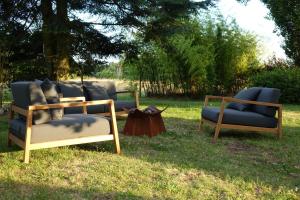 2 chaises et une table dans l'herbe dans l'établissement Gîte le Montillon, à Tour-en-Sologne