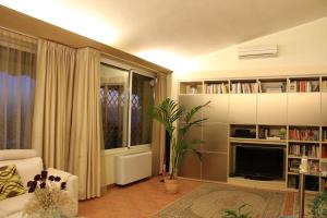 sala de estar con sofá, TV y ventana en Villa Adry, en Monteluro