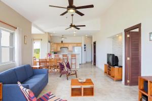 ein Wohnzimmer mit einem blauen Sofa und einer Küche in der Unterkunft Rio Dulce Ocean View Penthouse V-16 in Iguana
