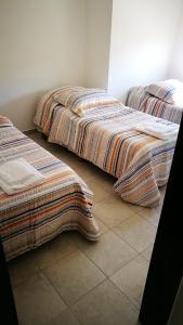 duas camas sentadas uma ao lado da outra num quarto em Depto 34 y 25, hasta 5 pasajeros, amplio y luminoso em La Plata