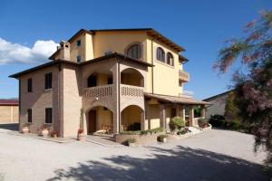 a large yellow building with a large driveway at Casale Ulivi in Grutti