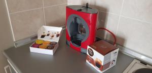 a red toaster and a box of donuts on a counter at Nice apartment in Niš