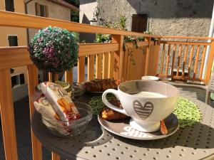 a table with a cup of coffee on a balcony at Suite Romantica Fuga in Roncone