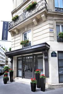 un bâtiment avec des pots de fleurs devant lui dans l'établissement Hôtel Bassano, à Paris