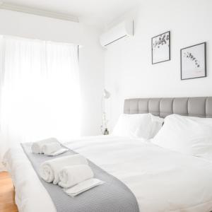 1 dormitorio blanco con toallas blancas en la cama en Modern design apartment near Acropolis 2, en Atenas