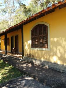 a yellow house with a window on the side of it at Canto da serrinha in Teresópolis