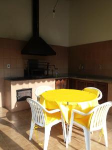 uma mesa amarela e cadeiras numa cozinha em Canto da serrinha em Teresópolis