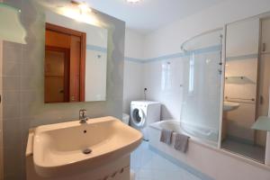 Un baño con lavabo, ducha e inodoro. en Appartamento Vandero, en Alba