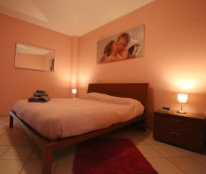 1 dormitorio con 1 cama, 2 lámparas y espejo en Appartamento Vandero, en Alba