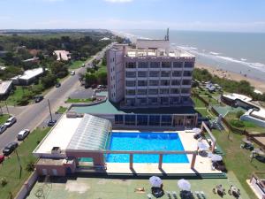 a hotel with a swimming pool next to a beach at Hotel Golf Internacional in Santa Teresita