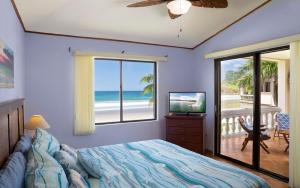 a bedroom with a bed and a view of the ocean at Villas Iguana A-8 Beachfront Condo in Iguana