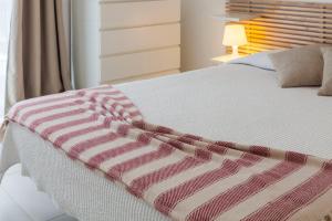a bed with a red and white blanket on it at Casa do Poema in Furnas