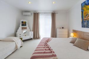 a white bedroom with a bed and a window at Casa do Poema in Furnas
