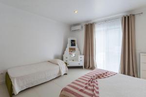 a bedroom with two beds and a window at Casa do Poema in Furnas