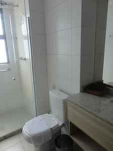 y baño blanco con aseo y ducha. en Beach Class Convention & Flats, en Recife