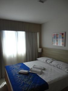 1 dormitorio con 1 cama grande y toallas. en Beach Class Convention & Flats, en Recife