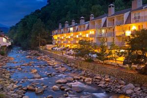 a river in front of a hotel at night at Gatlinburg River Inn in Gatlinburg