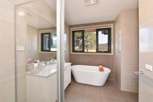 a bathroom with a tub and a sink at Horizon 7 in Pokolbin +10 photos