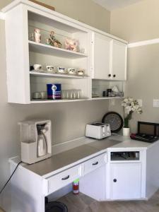a white kitchen with a counter with a coffee maker at Seaview White House in Stratford