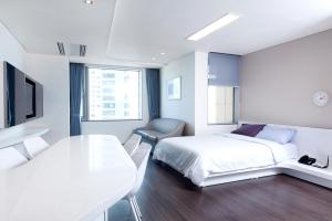 a bedroom with a bed and a table and a chair at Hanwha Resort Haeundae in Busan +32 photos