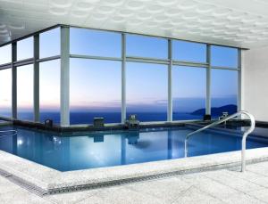 a swimming pool with a view of the ocean at Hanwha Resort Haeundae in Busan