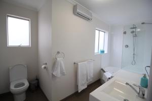 Baño blanco con aseo y lavamanos en Trinity Hill Apartments, en Hobart
