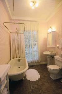 a bathroom with a toilet, sink and bathtub at 1872 Denham Inn in Monticello